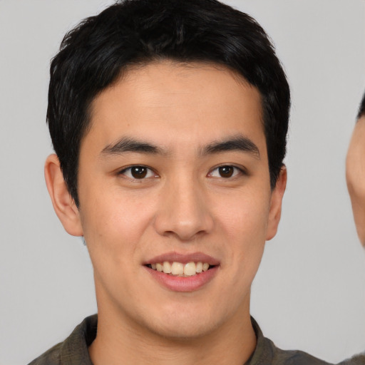 Joyful asian young-adult male with short  brown hair and brown eyes