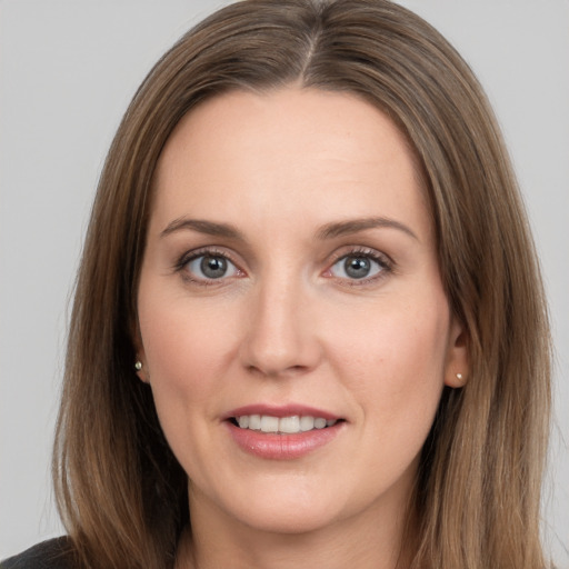 Joyful white young-adult female with long  brown hair and grey eyes