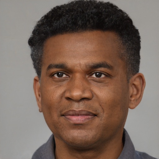 Joyful black adult male with short  black hair and brown eyes
