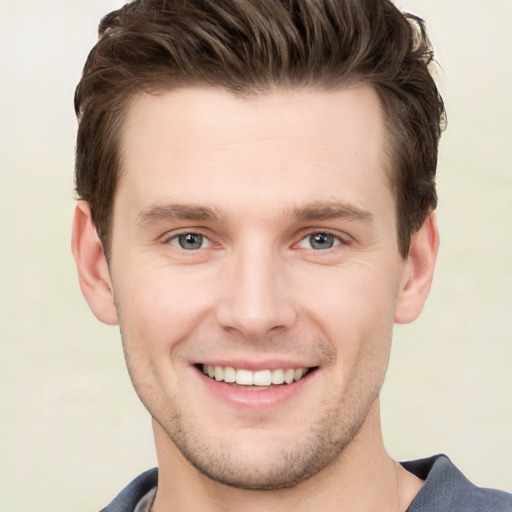 Joyful white young-adult male with short  brown hair and grey eyes