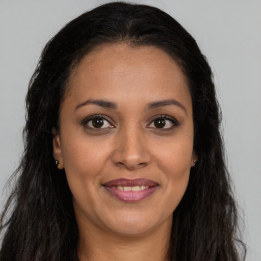 Joyful latino young-adult female with long  brown hair and brown eyes