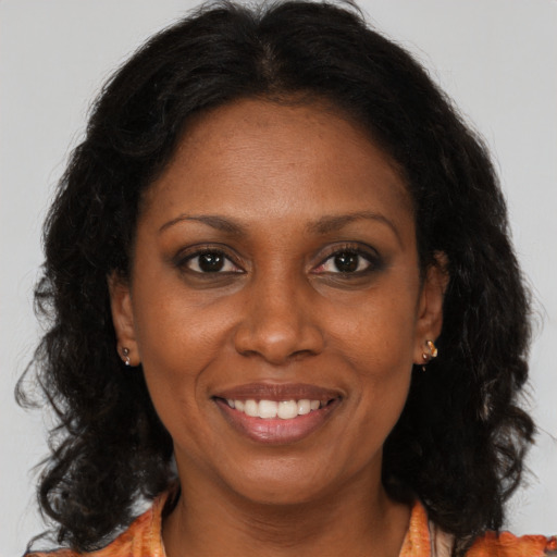 Joyful black adult female with long  brown hair and brown eyes