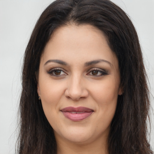 Joyful latino young-adult female with long  brown hair and brown eyes