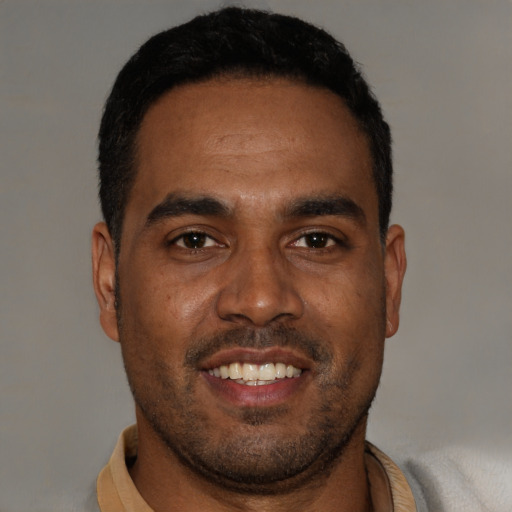 Joyful black young-adult male with short  black hair and brown eyes
