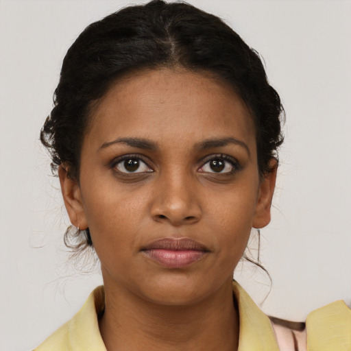 Joyful black young-adult female with short  brown hair and brown eyes