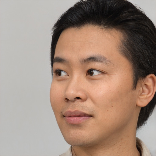 Joyful asian young-adult male with short  brown hair and brown eyes