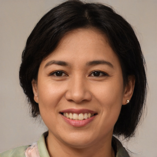 Joyful latino adult female with medium  brown hair and brown eyes