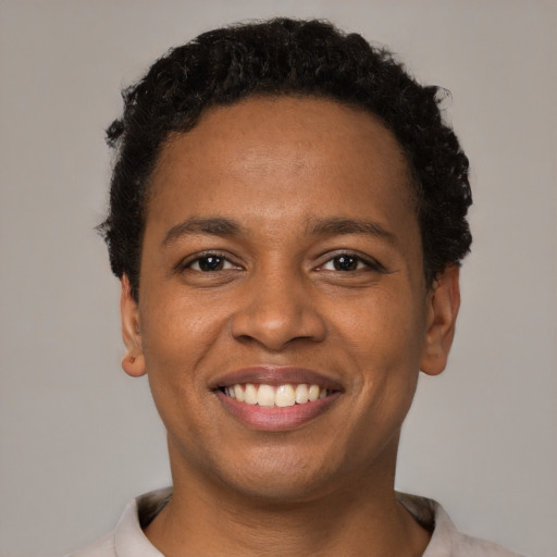 Joyful black young-adult male with short  black hair and brown eyes
