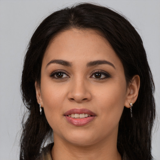 Joyful latino young-adult female with long  brown hair and brown eyes