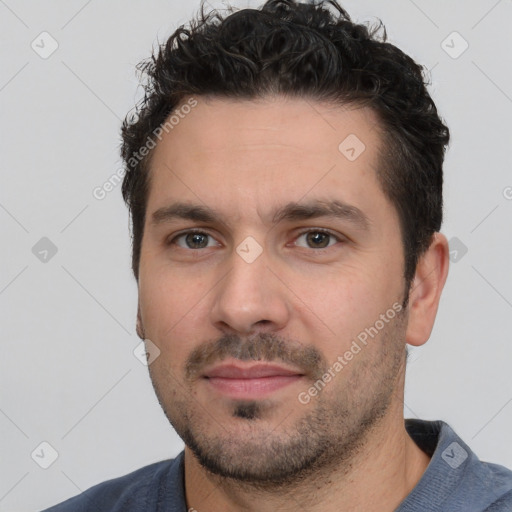 Joyful white young-adult male with short  black hair and brown eyes