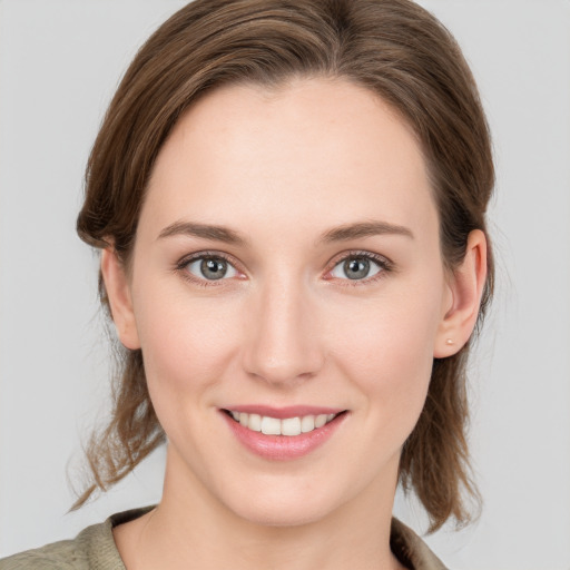 Joyful white young-adult female with medium  brown hair and grey eyes