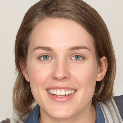 Joyful white young-adult female with medium  brown hair and blue eyes