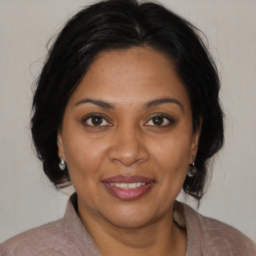 Joyful black adult female with medium  brown hair and brown eyes