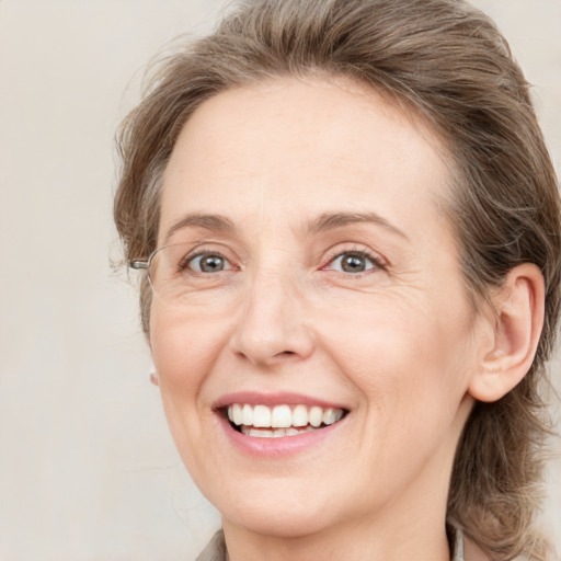 Joyful white adult female with medium  brown hair and green eyes