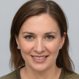 Joyful white young-adult female with medium  brown hair and grey eyes