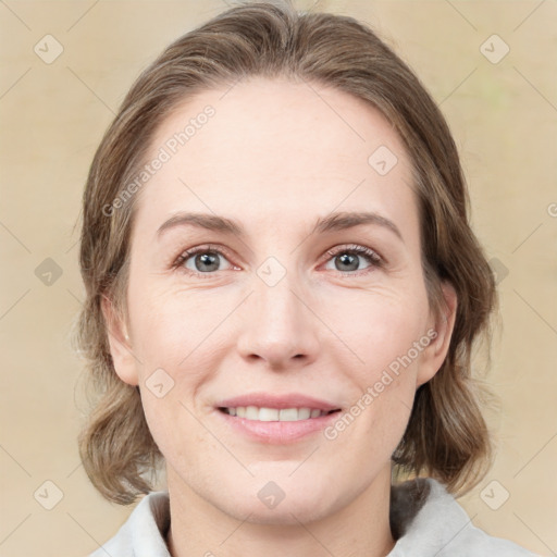 Joyful white young-adult female with medium  brown hair and green eyes