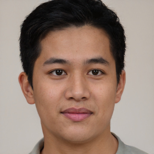 Joyful latino young-adult male with short  black hair and brown eyes
