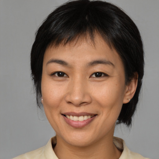 Joyful asian adult female with medium  brown hair and brown eyes