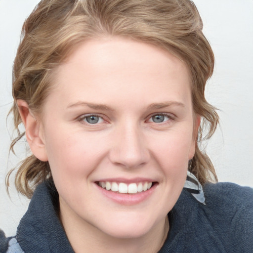 Joyful white young-adult female with medium  brown hair and blue eyes