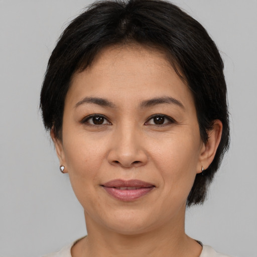 Joyful asian adult female with medium  brown hair and brown eyes
