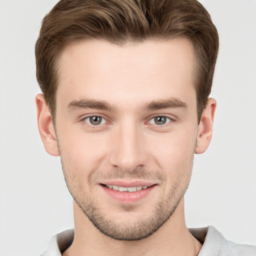 Joyful white young-adult male with short  brown hair and grey eyes