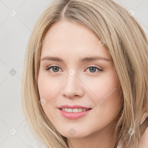 Joyful white young-adult female with long  brown hair and blue eyes