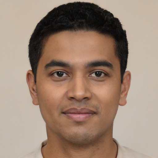 Joyful latino young-adult male with short  black hair and brown eyes