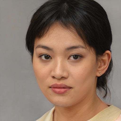 Joyful asian young-adult female with medium  brown hair and brown eyes