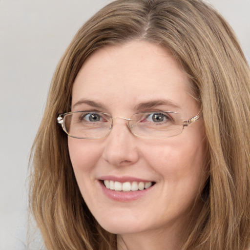 Joyful white young-adult female with long  brown hair and blue eyes