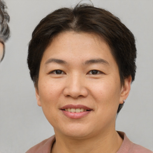 Joyful asian adult female with short  brown hair and brown eyes