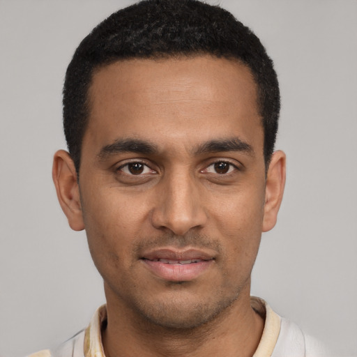 Joyful black young-adult male with short  black hair and brown eyes
