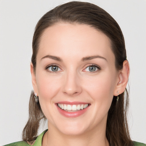 Joyful white young-adult female with long  brown hair and green eyes