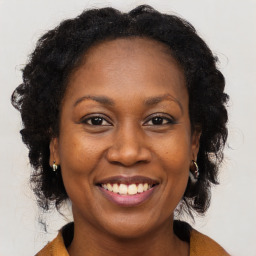 Joyful black adult female with medium  brown hair and brown eyes