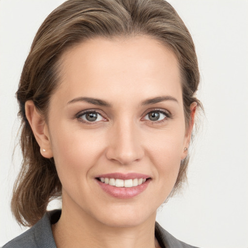 Joyful white young-adult female with medium  brown hair and grey eyes