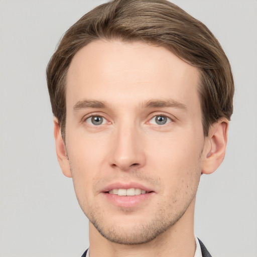 Joyful white young-adult male with short  brown hair and grey eyes