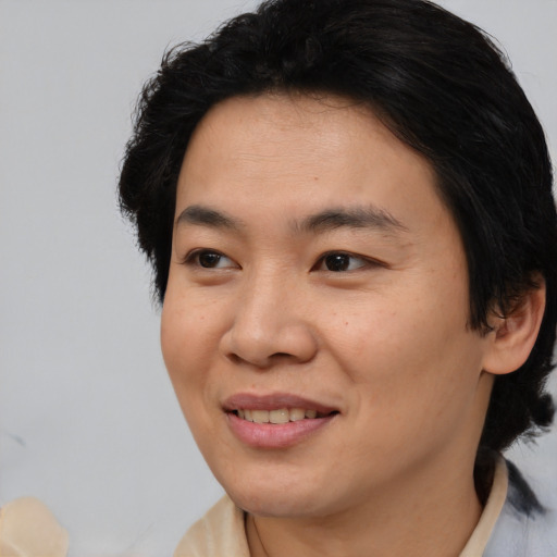 Joyful asian adult female with medium  brown hair and brown eyes