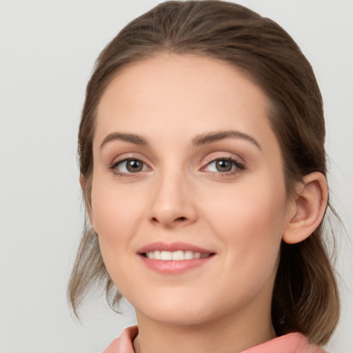 Joyful white young-adult female with medium  brown hair and grey eyes