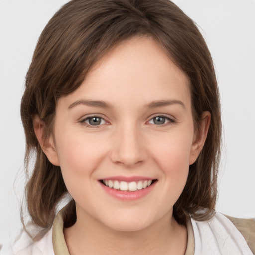 Joyful white young-adult female with medium  brown hair and grey eyes