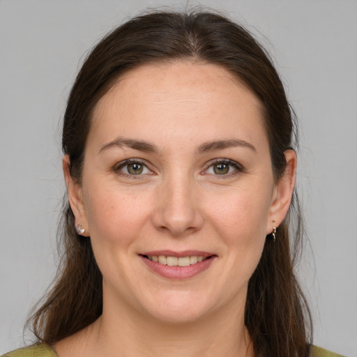 Joyful white adult female with medium  brown hair and green eyes