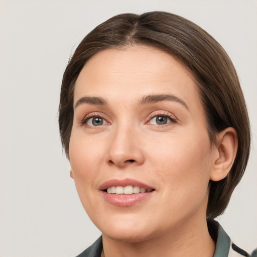 Joyful white young-adult female with medium  brown hair and grey eyes