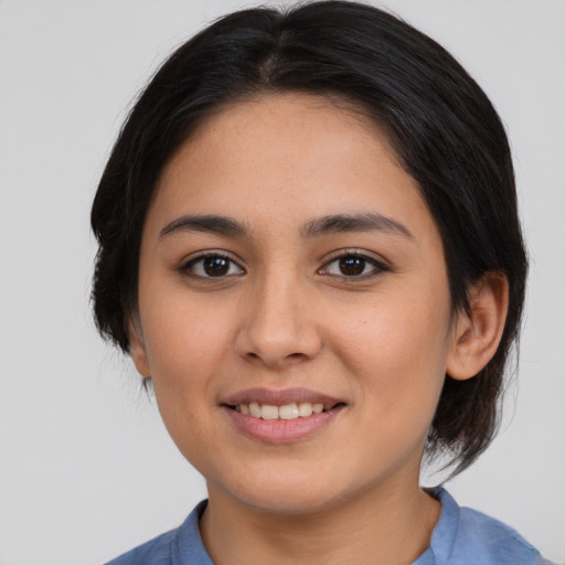 Joyful latino young-adult female with medium  brown hair and brown eyes