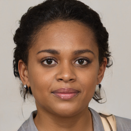 Joyful black young-adult female with medium  brown hair and brown eyes