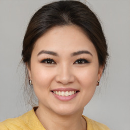 Joyful asian young-adult female with medium  brown hair and brown eyes