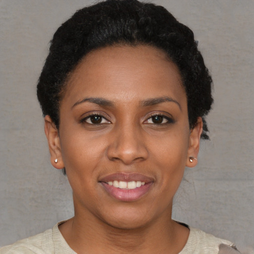 Joyful black young-adult female with short  brown hair and brown eyes