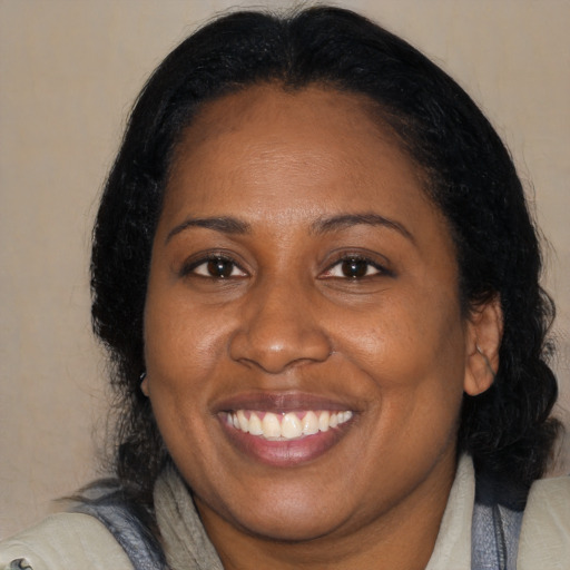 Joyful black adult female with medium  black hair and brown eyes