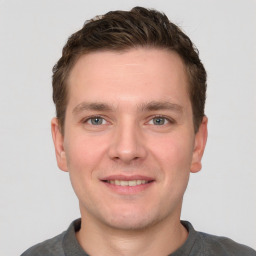 Joyful white young-adult male with short  brown hair and grey eyes