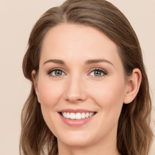 Joyful white young-adult female with long  brown hair and green eyes