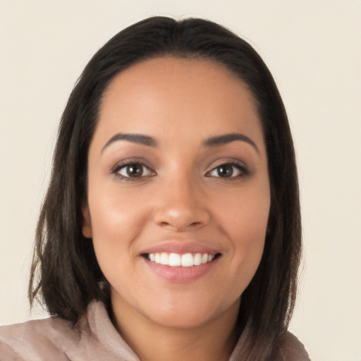 Joyful latino young-adult female with long  brown hair and brown eyes