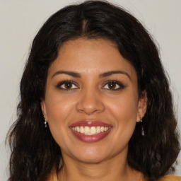 Joyful latino young-adult female with medium  brown hair and brown eyes