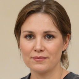 Joyful white adult female with medium  brown hair and grey eyes